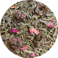 Té verde suelto con pétalos de flor seca color cereza en mezcla detallada.