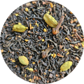 Mezcla de té negro con especias incluyendo cardamomo y clavo, textura suelta y oscura.
