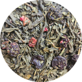 Mezcla de té verde con trozos de frutas del bosque secos en primer plano.