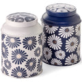 Lata Amami de 175gr con diseño de margaritas blancas y centro amarillo sobre fondo azul y blanco.