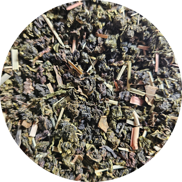 Té azul con hojas secas verdes y marrones, trozos de limón y algas en mezcla artesanal.