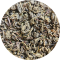 Hojas secas de té verde Moruno en tonos verdes y marrones, pulverizadas y enrolladas.