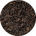 Hojas secas de té Pu Erh rojo oscuro con tonos marrones y textura rizada.