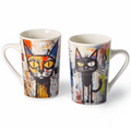Tazas blancas con ilustraciones coloridas de gatos estilizados en tonos naranja y negro con fondo abstracto.