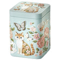 Lata metálica azul claro con diseño de gato y mariposas rodeados de flores rosas y beige.