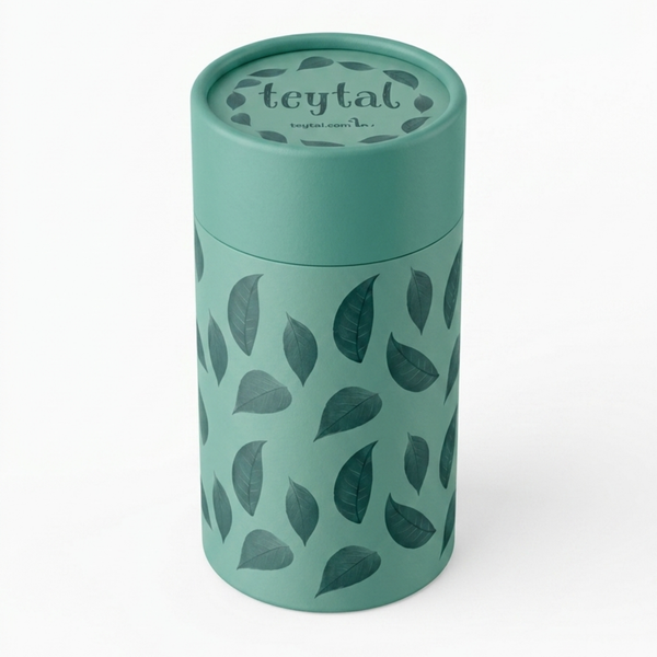 Bote redondo verde con tapa y diseño de hojas oscuras para guardar té.
