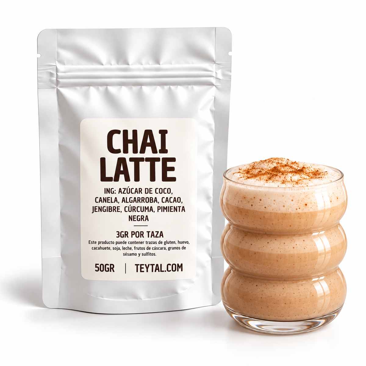 Bolsa blanca de chai latte en polvo junto a un vaso de vidrio con bebida cremosa y espuma.