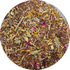 Mezcla suelta de té rooibos con pétalos secos de flores amarillas, rosas y hojas verdes.